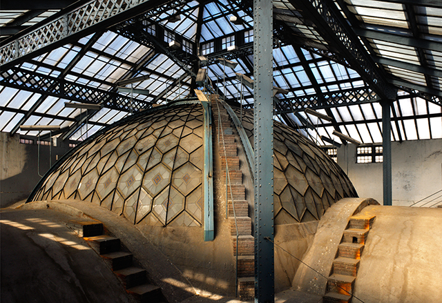 Interior de una construcción con cúpula y estructuras metálicas expuestas.